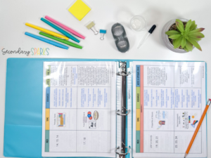 physical science curriculum pacing guide in a blue binder with school supplies